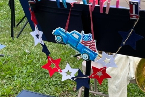 black music stand decorated for Independence Day with red and white stars and a blue truck displaying an American flag