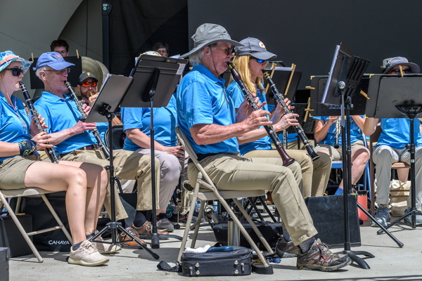 clarinet players in blue shirts and various hats, seated
