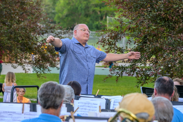 man in blue shirt conducting band