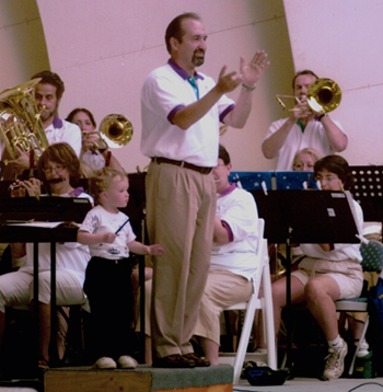 Brian Hopwood conducting the Boulder Concert Band, assisted by Joey. Photo used with permission