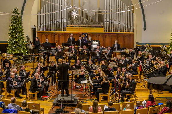 conductor before a large ensemble of wind and percussion instruments