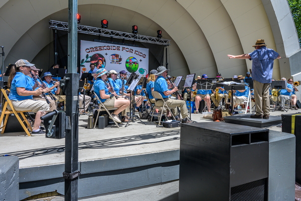 band in blue shirts playing inside band shell