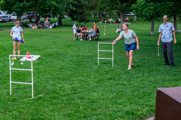 people in summer attire, playing a lawn game
