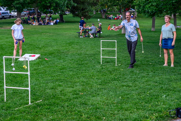 people in summer attire, playing a lawn game