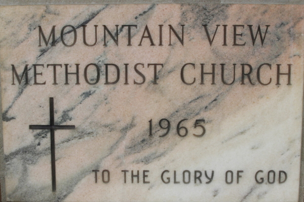 beige marble sign with a cross, reading 'Mountain View Methodist Church 1965 To the Glory of God' 