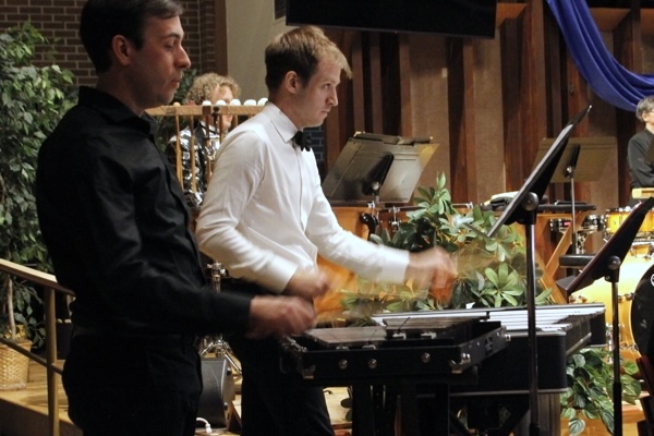 two men playing mallet percussion, one in all black and one wearing a white shirt