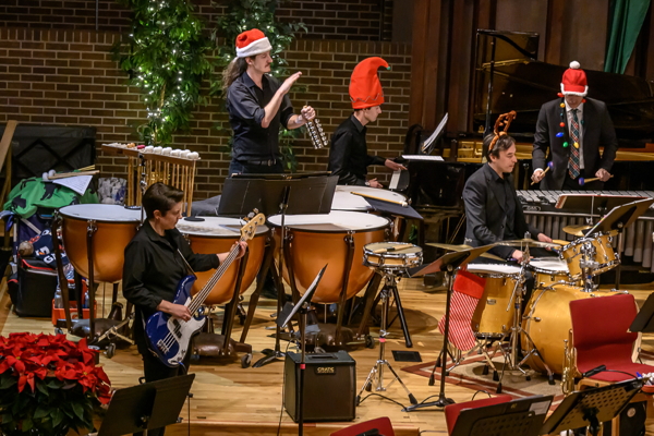 people dressed in black, playing jingle bells, drum set and vibraphone