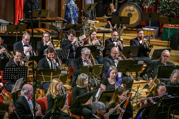 people dressed in concert black attire, playing clarinet, flute, trombone, trumpet, gong, and saxophone