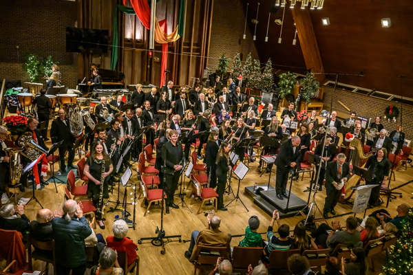 high-angle view of the band standing, with director taking a bow from the podium