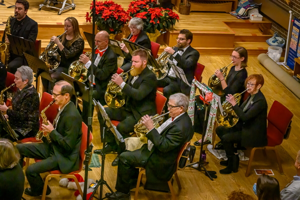 people  dressed in black concert attire, playing saxophones and french horns