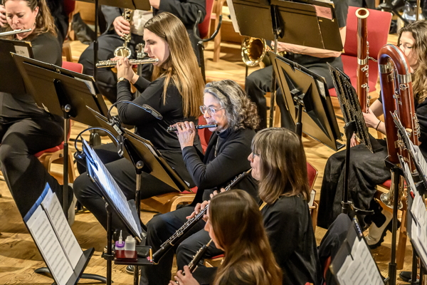 women dressed in black, seated and playing oboe, flutes and bassoon