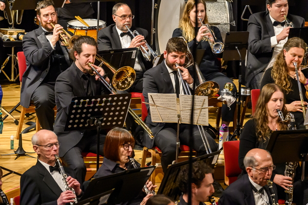 front view of a small portion of the band, showing four trumpet players, three trombonists, and four clarinetists