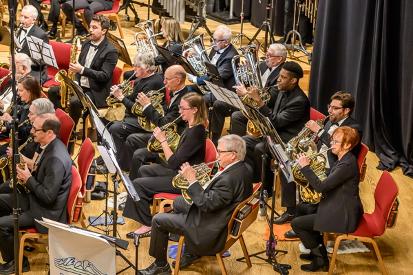 side view of a group of musicians playing french horns
