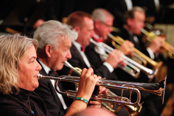 five people playing trumpet