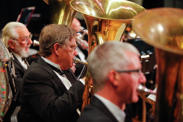 three men playing tuba